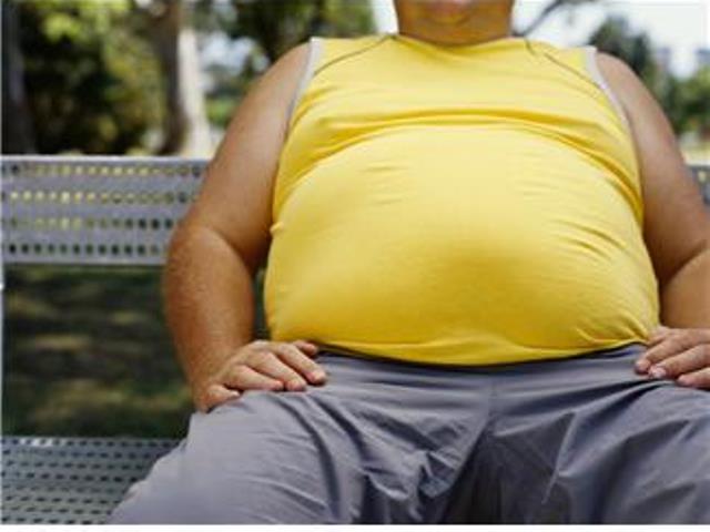 mid section view of a man sitting on a bench in a park --- Image by © Royalty-Free/Corbis